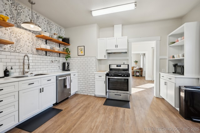 kitchen featuring appliances with stainless steel finishes, light wood-type flooring, white cabinetry, and sink