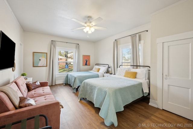 bedroom featuring hardwood / wood-style floors, ceiling fan, and crown molding