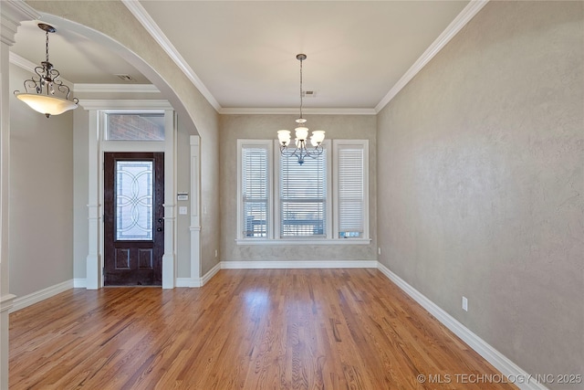 foyer with a notable chandelier, hardwood / wood-style floors, and ornamental molding