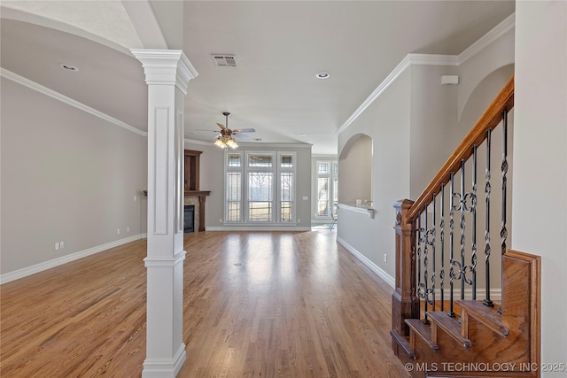 entryway featuring decorative columns, ceiling fan, ornamental molding, and light hardwood / wood-style flooring