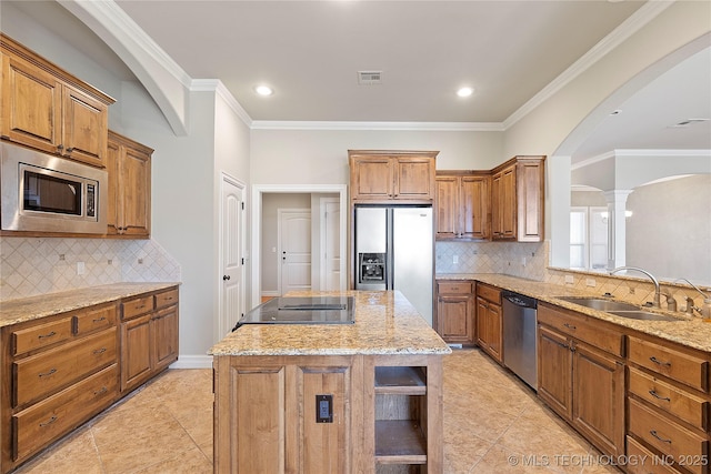 kitchen with sink, stainless steel appliances, a center island, and tasteful backsplash