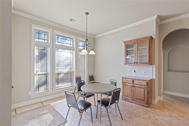 dining room featuring an inviting chandelier, ornamental molding, and light tile patterned floors