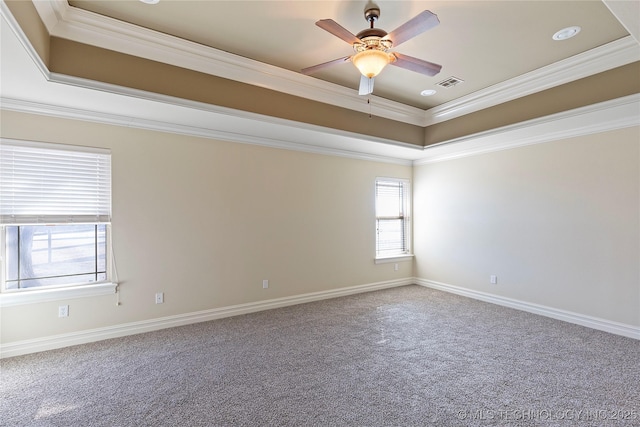 carpeted spare room featuring ceiling fan, crown molding, and a tray ceiling