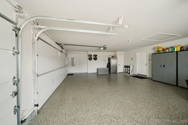 garage with stainless steel fridge, electric panel, and a garage door opener