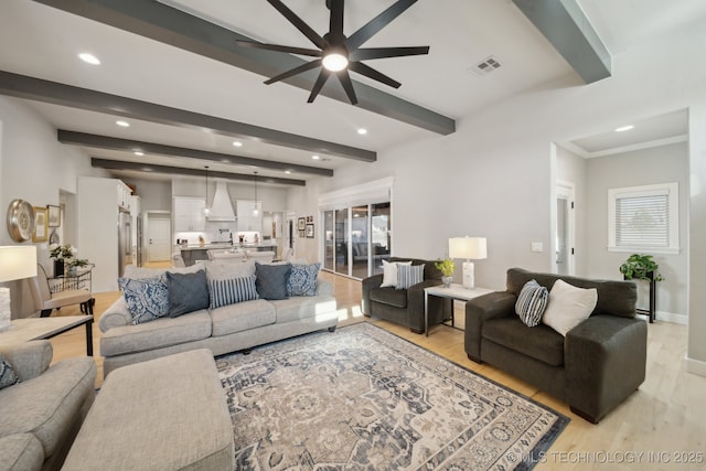 living room featuring beamed ceiling, ceiling fan, and light hardwood / wood-style floors