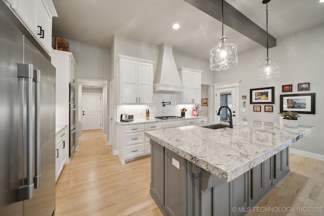 kitchen with pendant lighting, a large island with sink, sink, appliances with stainless steel finishes, and white cabinetry