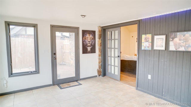 doorway with french doors and wooden walls