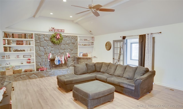 living room with ceiling fan, built in features, a fireplace, vaulted ceiling with beams, and light hardwood / wood-style floors