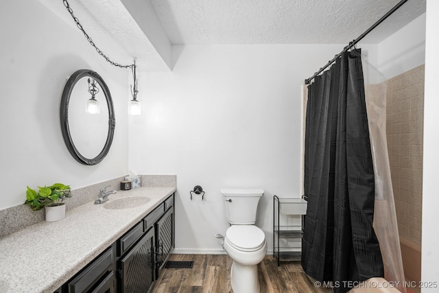 full bathroom with a textured ceiling, toilet, wood finished floors, vanity, and baseboards