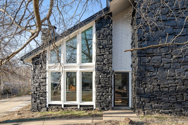 view of home's exterior featuring stone siding and a chimney