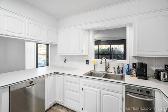 kitchen with light countertops, stainless steel dishwasher, a sink, and white cabinetry