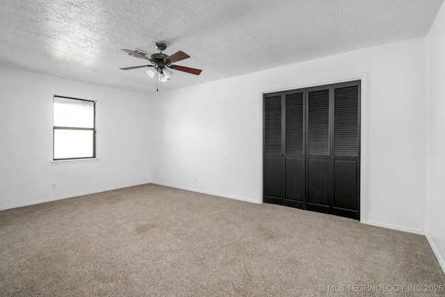 unfurnished bedroom with ceiling fan, a textured ceiling, carpet floors, baseboards, and a closet