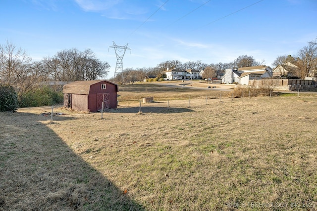 view of yard with an outbuilding, fence, and a shed