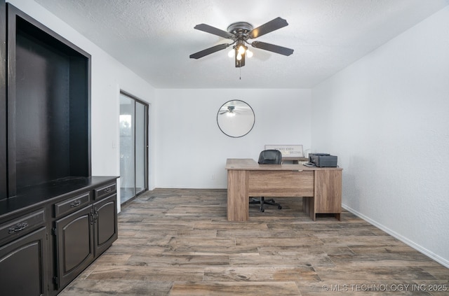 home office featuring a textured ceiling, wood finished floors, and a ceiling fan