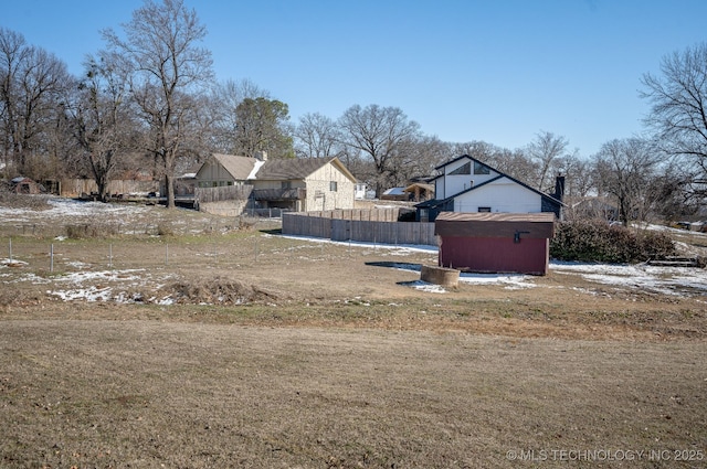 view of yard featuring an outbuilding, a storage unit, and fence