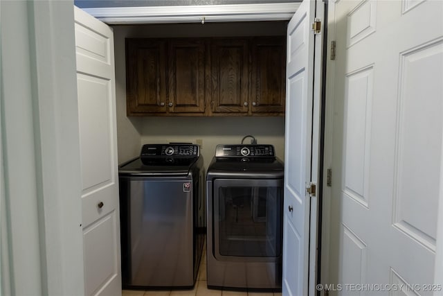 washroom with cabinets, light tile patterned floors, and washer and dryer