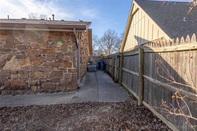 view of side of home with central AC