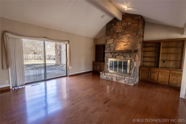 unfurnished living room with a stone fireplace, dark wood-type flooring, and lofted ceiling with beams