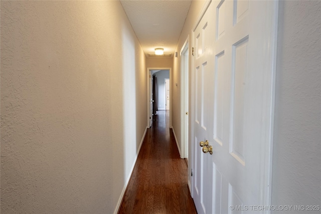 hall with dark hardwood / wood-style flooring and a textured ceiling