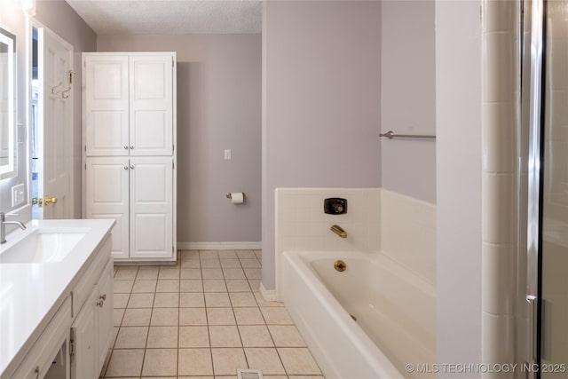 bathroom featuring tile patterned flooring, vanity, a textured ceiling, and a bathing tub