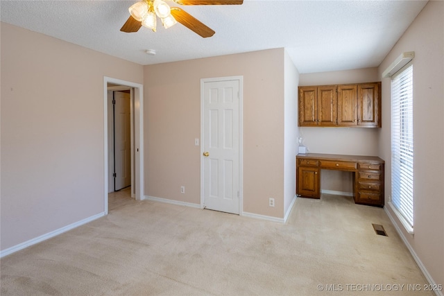 interior space featuring light carpet, a textured ceiling, and ceiling fan