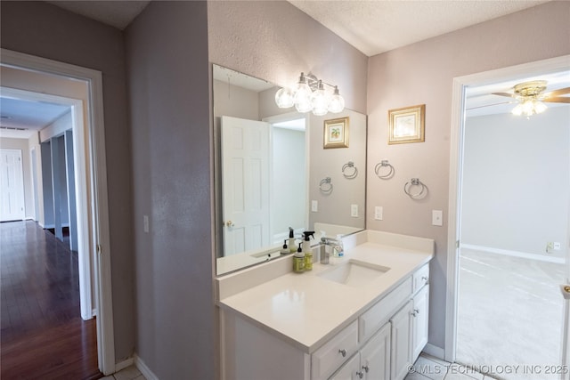 bathroom with vanity, ceiling fan, and a textured ceiling