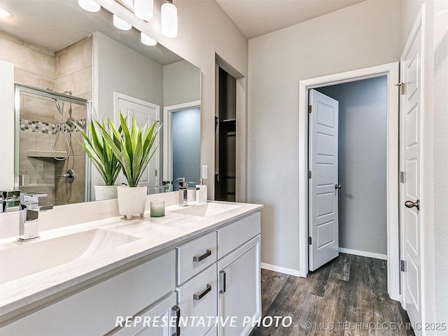 bathroom with hardwood / wood-style flooring, vanity, and a shower with shower door