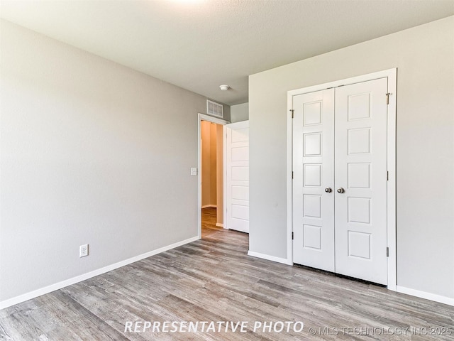 unfurnished bedroom with light hardwood / wood-style floors and a closet