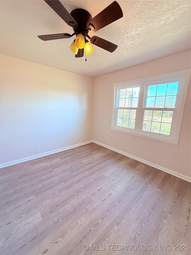 empty room with ceiling fan, light hardwood / wood-style floors, and a textured ceiling