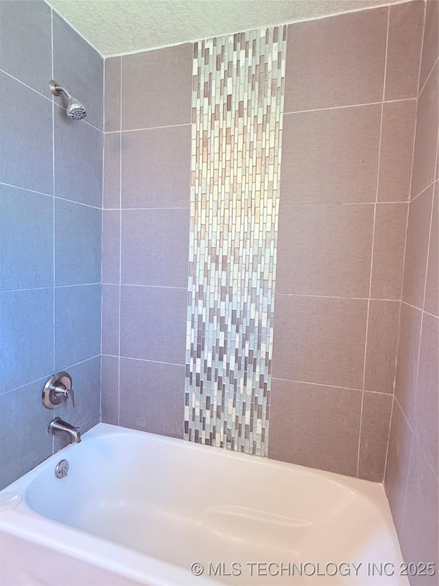 bathroom featuring tiled shower / bath