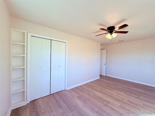 unfurnished bedroom with a closet, light hardwood / wood-style floors, and ceiling fan