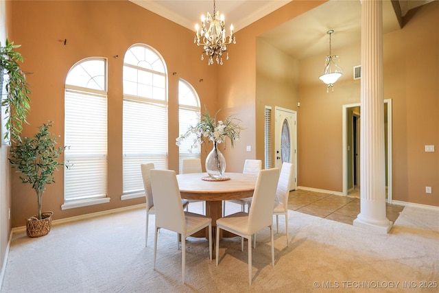 dining room featuring light carpet, an inviting chandelier, ornate columns, and ornamental molding