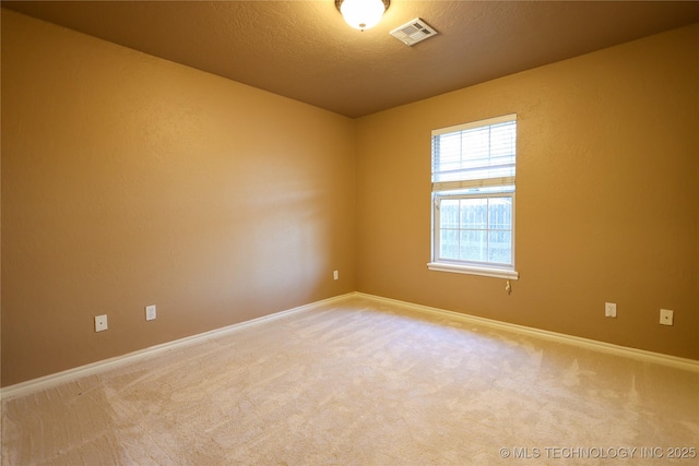 unfurnished room with carpet flooring and a textured ceiling