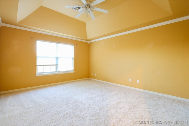 carpeted spare room featuring a raised ceiling, ceiling fan, and ornamental molding