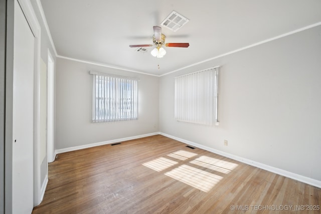 unfurnished room featuring hardwood / wood-style flooring, ceiling fan, and crown molding