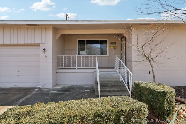 view of exterior entry with covered porch and a garage