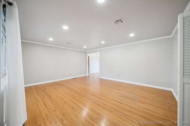 spare room with light wood-type flooring and crown molding