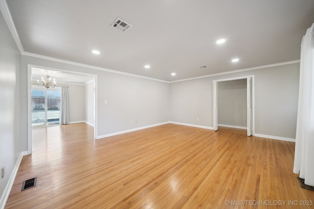 spare room featuring crown molding, light hardwood / wood-style flooring, and an inviting chandelier