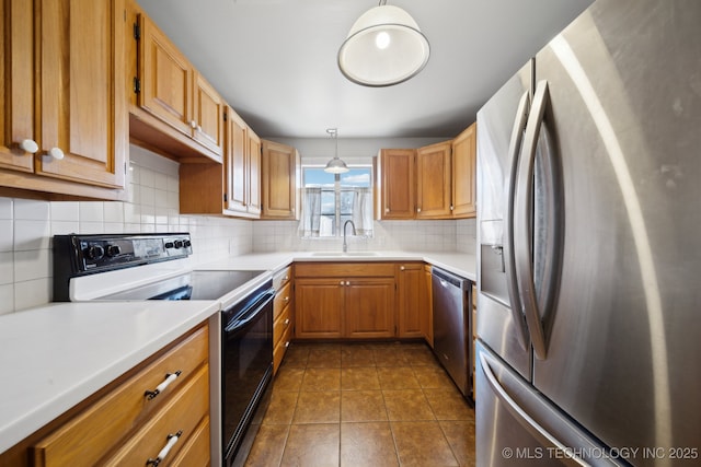 kitchen with appliances with stainless steel finishes, backsplash, dark tile patterned floors, sink, and hanging light fixtures