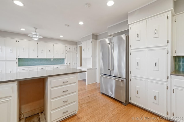 kitchen with white cabinets, decorative backsplash, ceiling fan, light wood-type flooring, and high end fridge