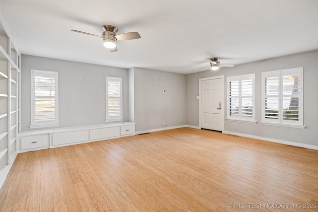 spare room featuring ceiling fan, a healthy amount of sunlight, and light hardwood / wood-style floors