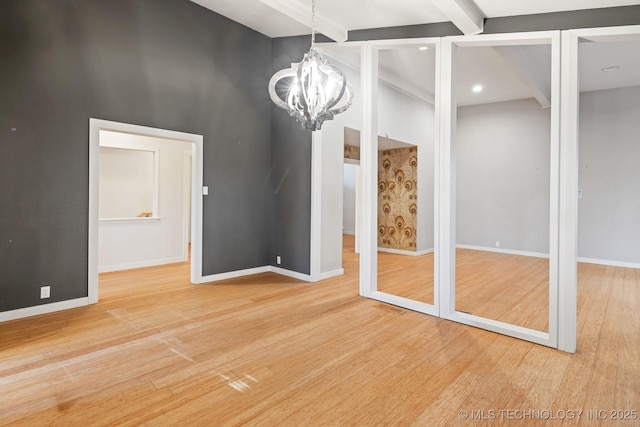 unfurnished dining area with beam ceiling, a chandelier, and wood-type flooring