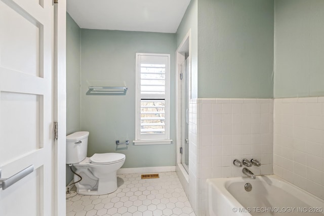 bathroom featuring tile patterned floors, a bathtub, and toilet