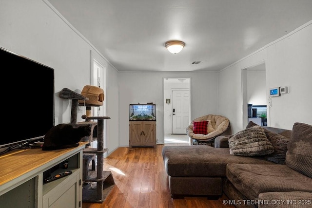 living room featuring wood-type flooring and ornamental molding