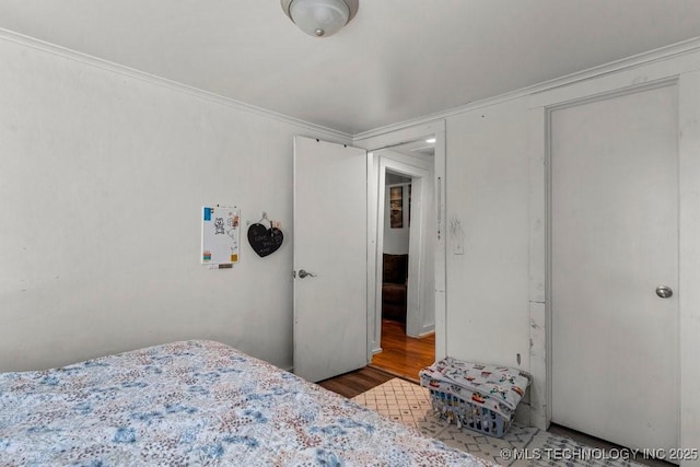 bedroom with hardwood / wood-style floors and ornamental molding