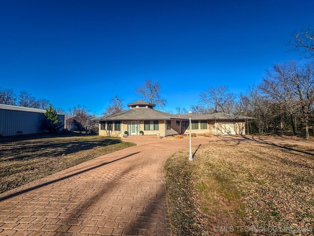 single story home with a garage and a front lawn