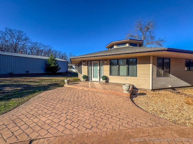 back of property featuring a yard and a patio area