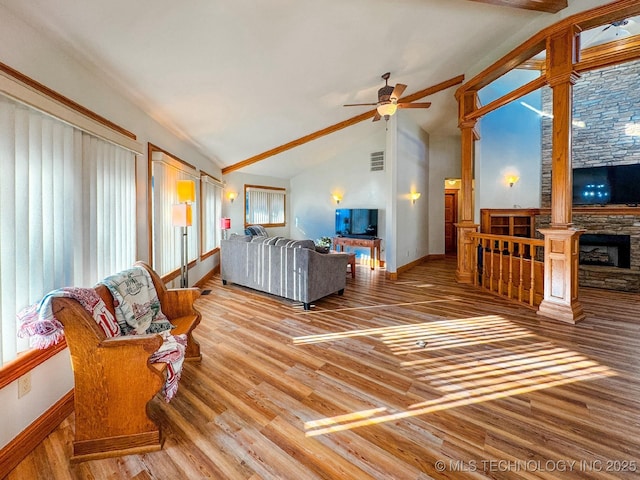 living room with ceiling fan, a fireplace, vaulted ceiling, and hardwood / wood-style floors