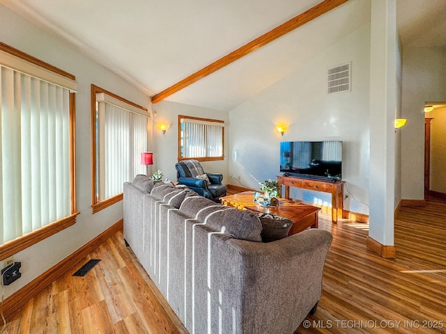 living room featuring wood-type flooring and vaulted ceiling with beams