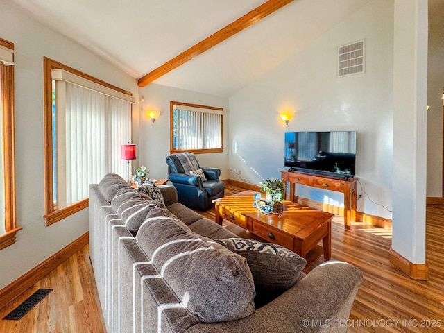 living room featuring lofted ceiling with beams and light hardwood / wood-style flooring